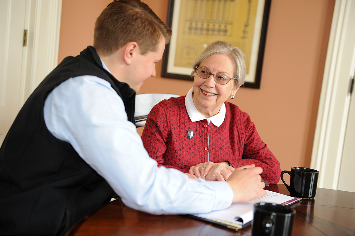 Alan Baldwin speaking with a woman about retirement in the office